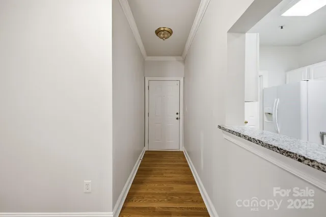 a view of a hallway with wooden floor and staircase