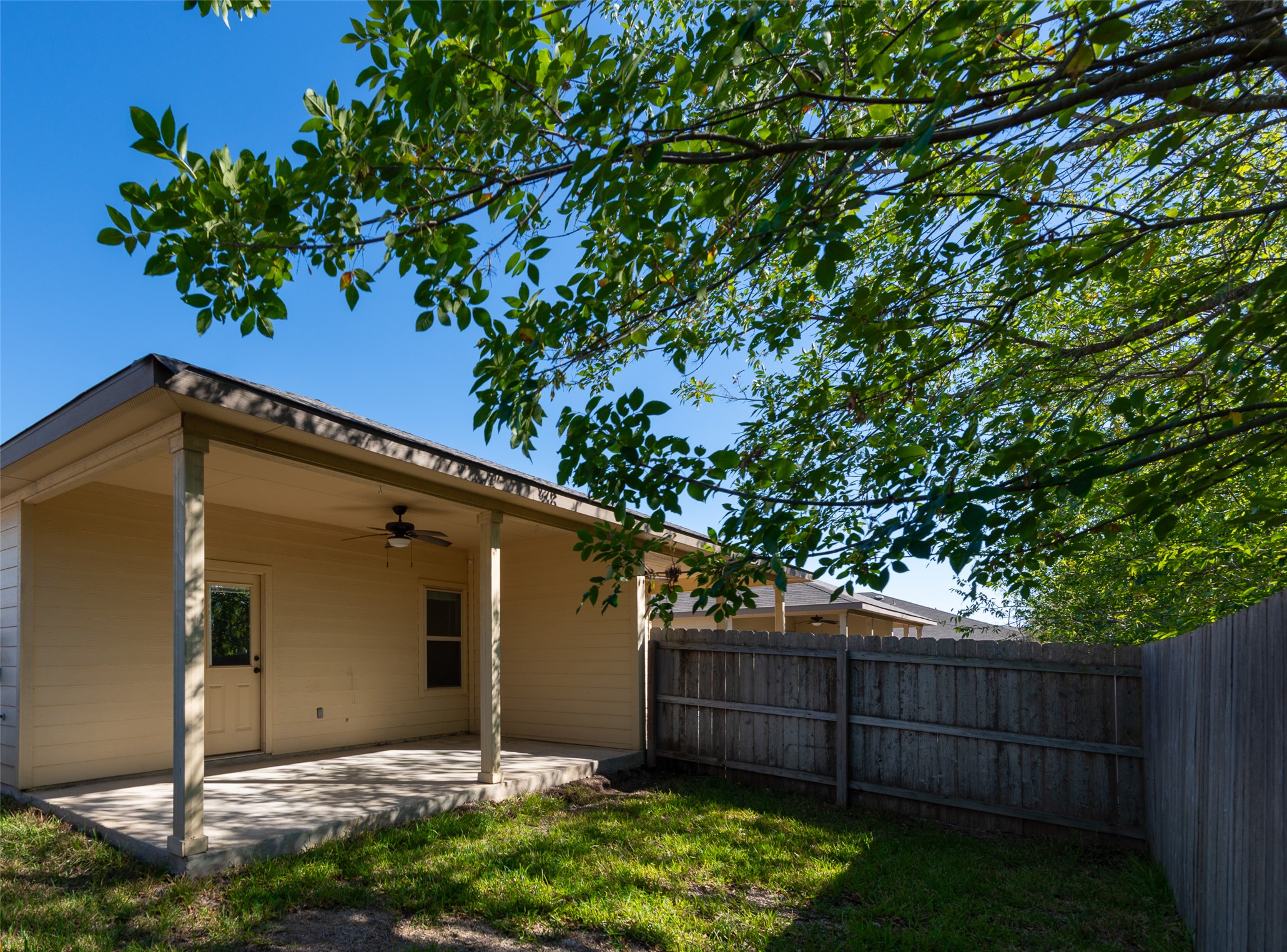 245 Joanne Loop, Unit B Buda, TX 78610 - Photo 30 of 33 Rear patio off of primary bedroom and back yard. Private yard (not shared) and privacy fence. No neighbors currently behind offering additional privacy and quiet.