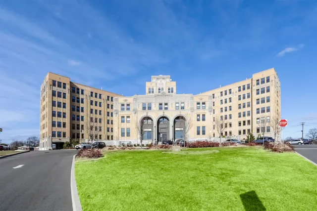 a view of a large building with garden and deck