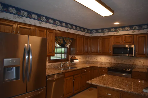 a kitchen with granite countertop cabinets sink and granite counter top