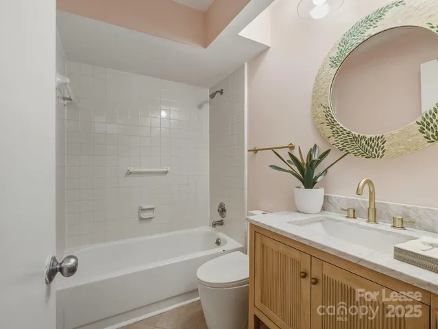 a bathroom with a granite countertop toilet a sink and a mirror