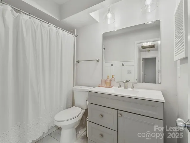 a bathroom with a sink vanity mirror and toilet