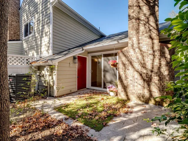 a view of a yard with plants and large trees