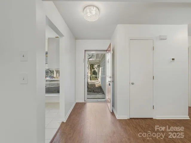 a view of a hallway with wooden floor and closet