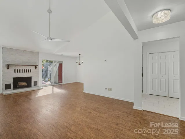 a view of an empty room with a fireplace and a window