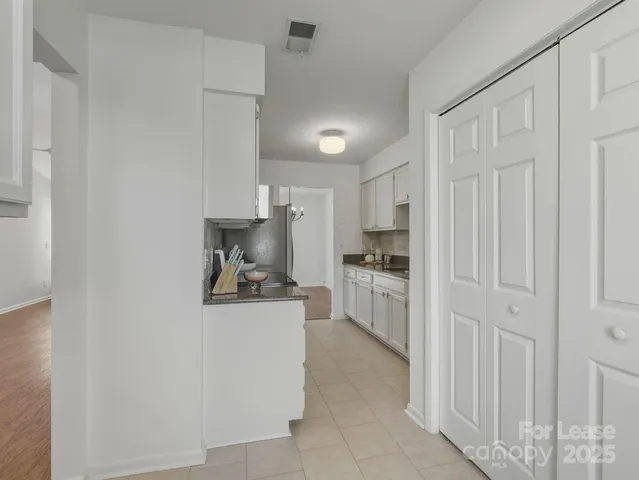 a kitchen with white cabinets and white appliances