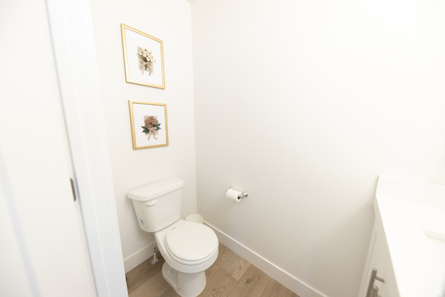 1404 East Rustic Wood Court Sandy, UT 84092 - Photo 11 of 33 Powder room with light wood-finish flooring, white walls, and a white vanity with a white countertop