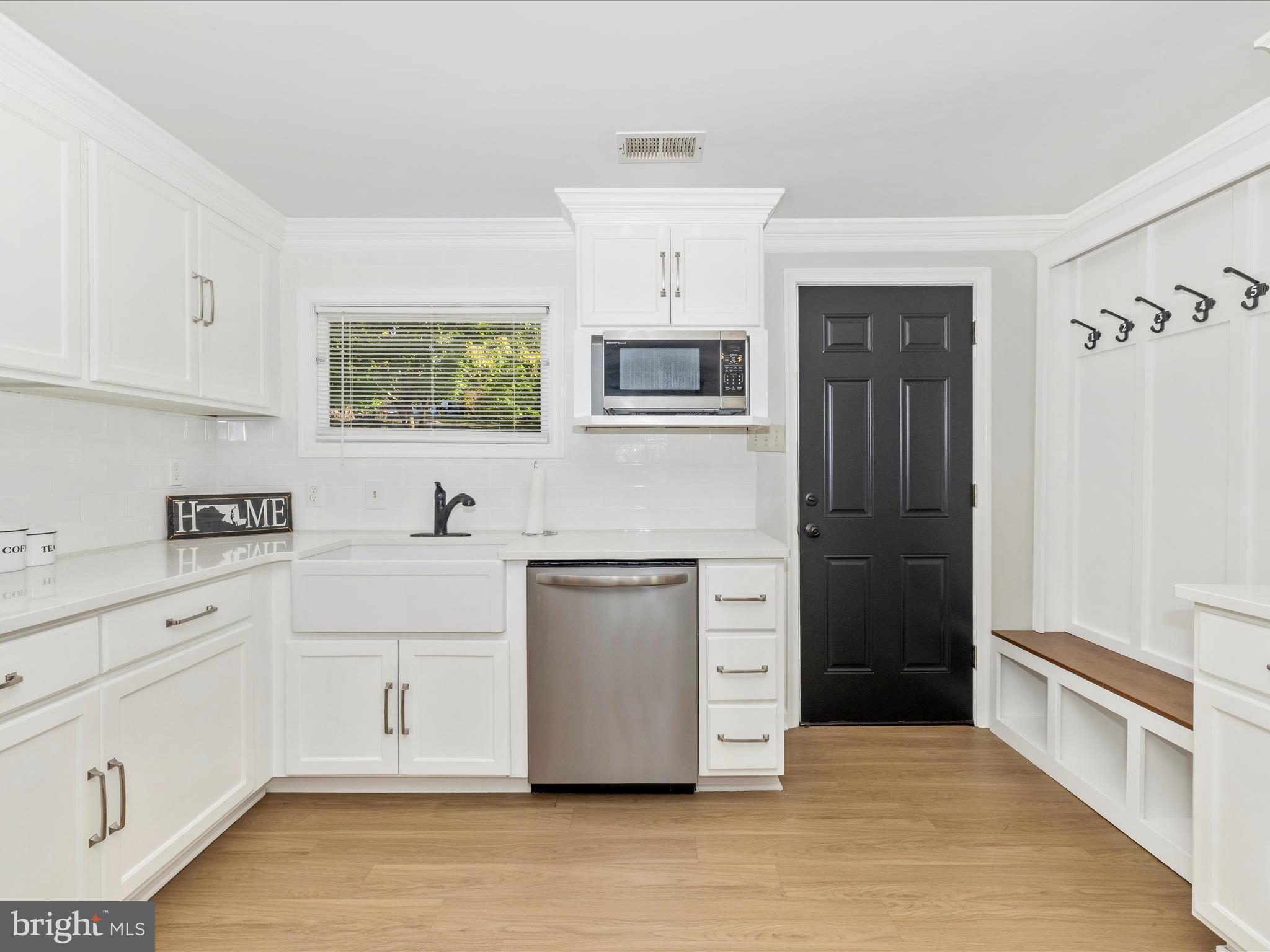1410 Woodenbridge Lane Mount Airy, MD 21771 - Photo 13 of 50 a kitchen with stainless steel appliances white cabinets and wooden floor