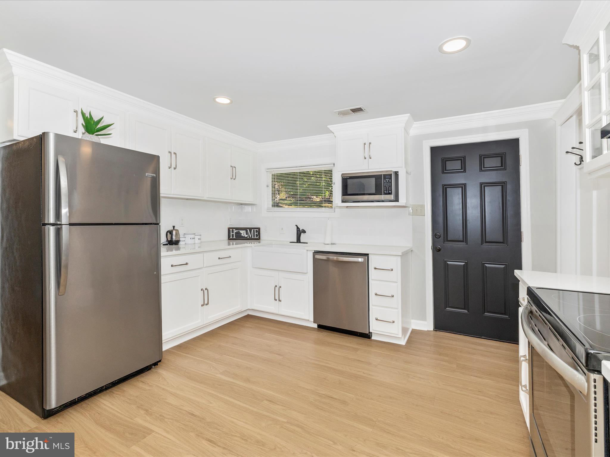 1410 Woodenbridge Lane Mount Airy, MD 21771 - Photo 14 of 50 a kitchen with stainless steel appliances a refrigerator sink and microwave