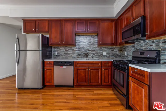a kitchen with stainless steel appliances granite countertop a refrigerator stove top oven a sink and dishwasher
