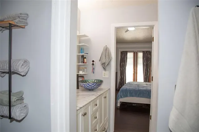 a en suite bathroom with a granite countertop sink and a mirror