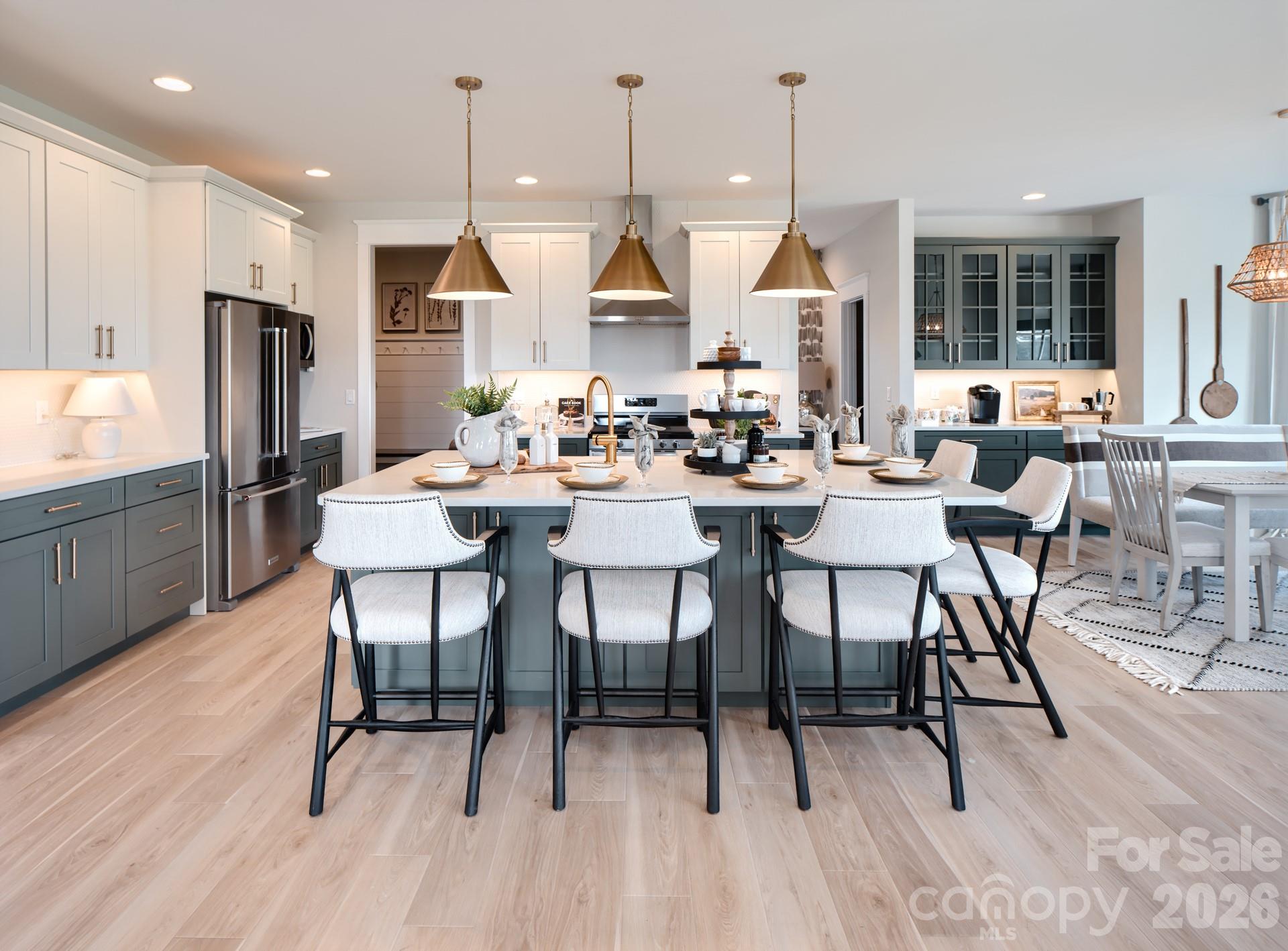 2 Pinnacle Way, Unit COVINGTON York, SC 29745 - Photo 12 of 46 a dining room with stainless steel appliances kitchen island granite countertop a table chairs and a refrigerator
