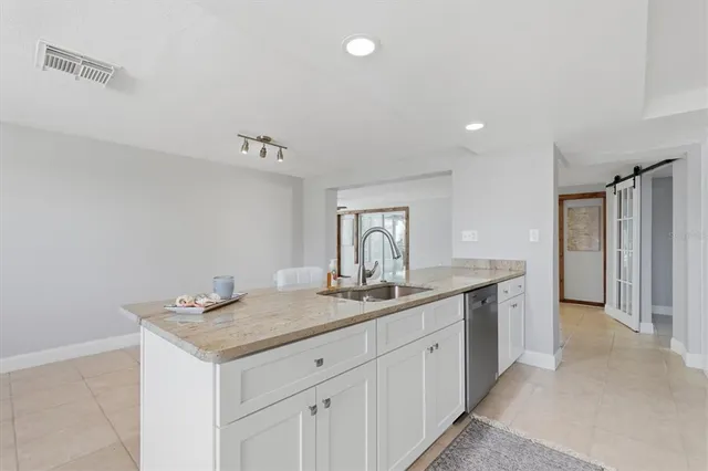 a kitchen with stainless steel appliances granite countertop a sink and dishwasher a stove top oven with white cabinets