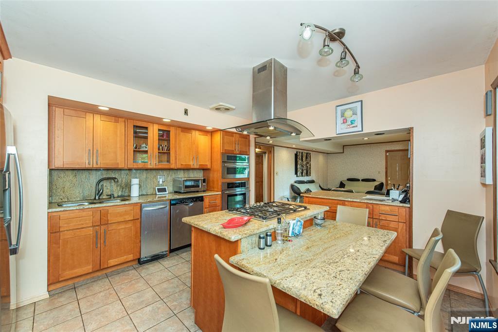 12 Abbott Road Wayne, NJ 07470 - Photo 15 of 49 a kitchen with stainless steel appliances granite countertop a sink dishwasher and a stove with wooden floor