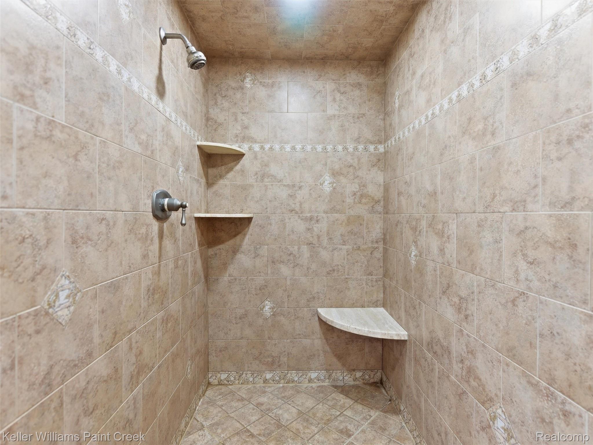 2842 Manorwood Road Troy, MI 48085 - Photo 50 of 72 Tiled shower with a mosaic accent band, integrated corner shelving, corner bench seating, and a brushed nickel showerhead and control