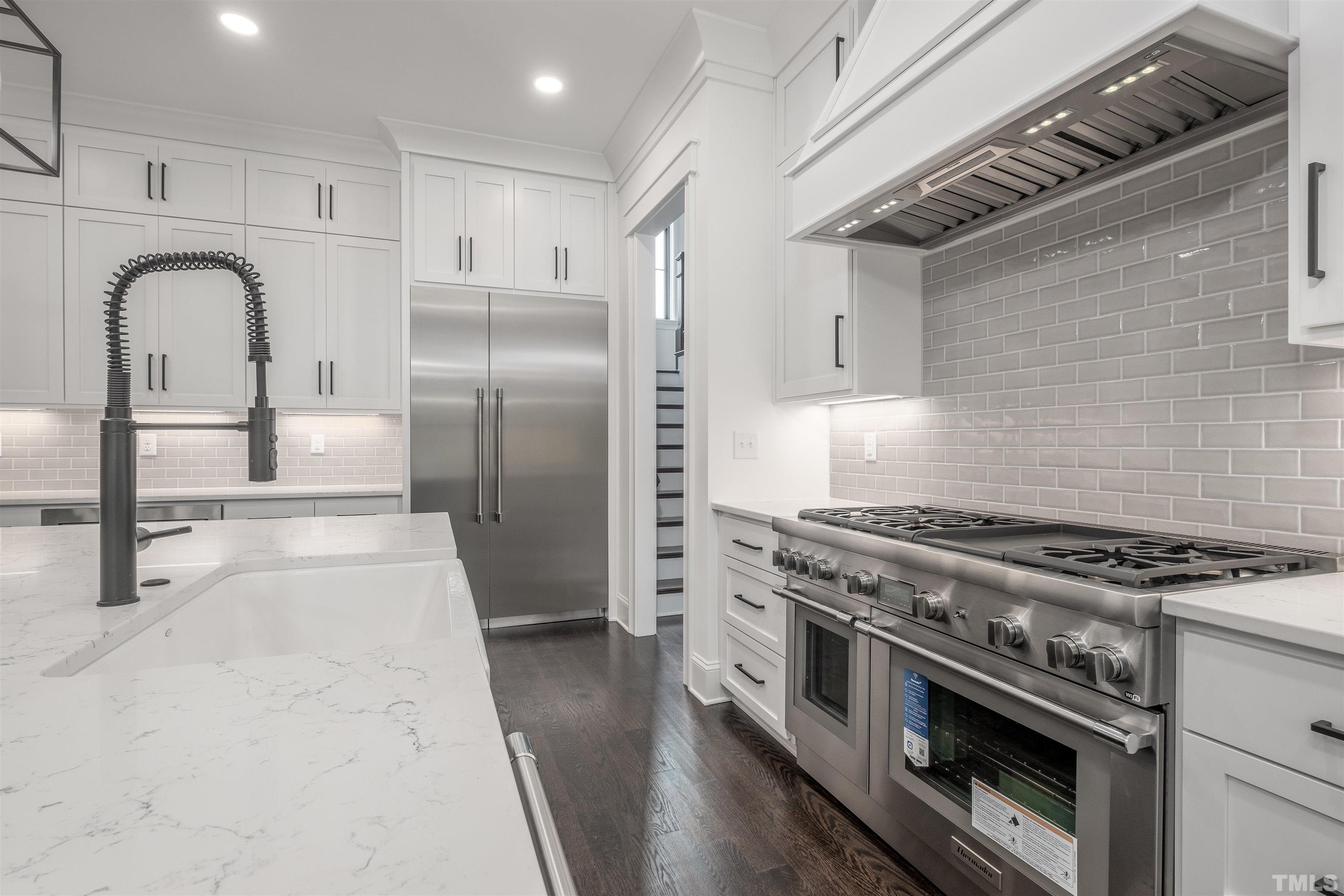5011 Ten-Ten Road Apex, NC 27539 - Photo 16 of 49 a kitchen with stainless steel appliances granite countertop a stove a sink and a refrigerator