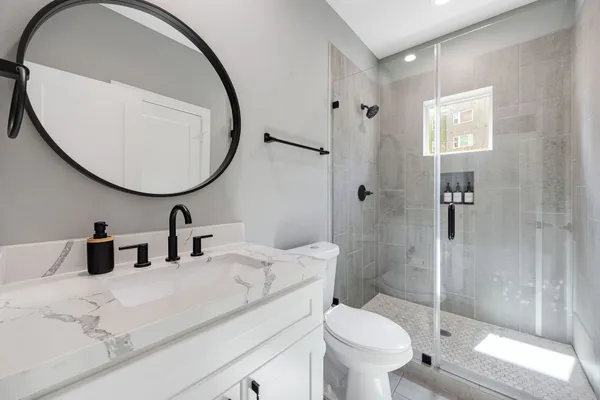 a bathroom with a toilet sink and mirror