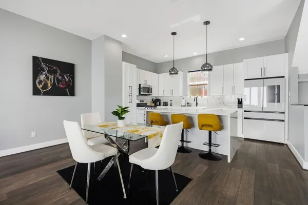 a living room with stainless steel appliances kitchen island granite countertop wooden floor dining table chairs and wooden floor