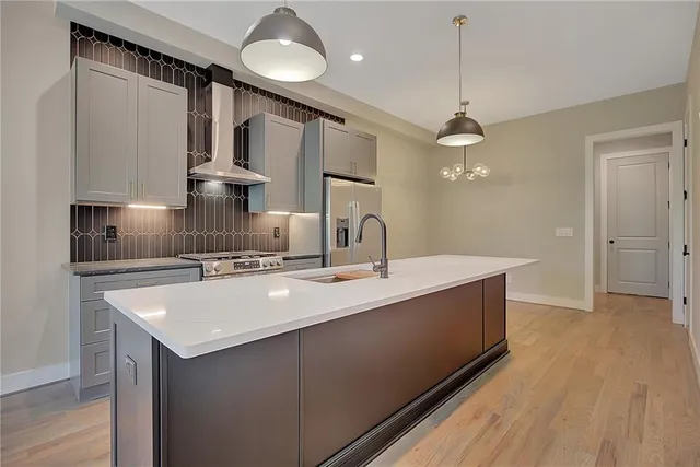 a kitchen with granite countertop a sink cabinets and stainless steel appliances