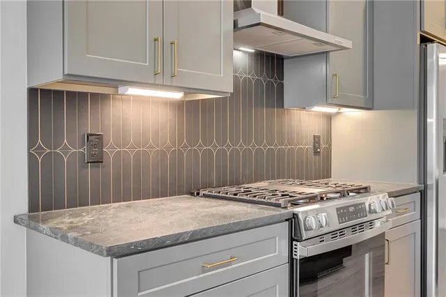 a large kitchen with kitchen island a large counter top space appliances and cabinets