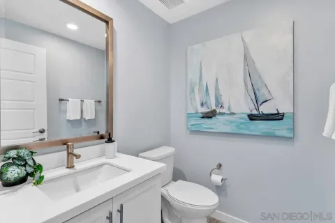 a bathroom with a granite countertop sink a toilet and a mirror