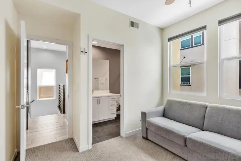 a living room with furniture and a glass door shower