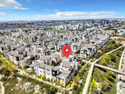 an aerial view of residential houses with yard and mountain view in back