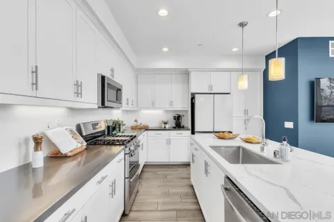 a kitchen that has a sink a stove and a oven
