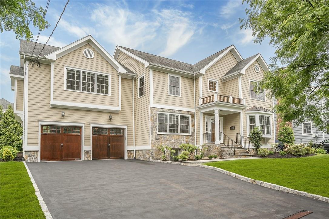 Custom built colonial with beautiful stone and mahogany garage doors.