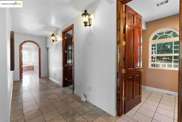 a spacious bedroom with a bed a window and dresser