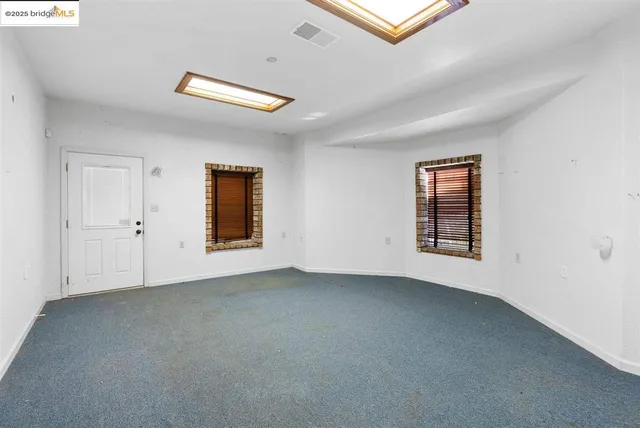 an empty room with closet and a window