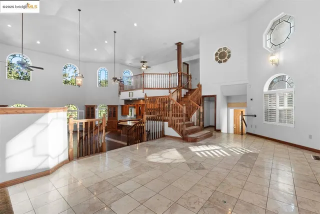 a hall with stainless steel appliances granite countertop a sink a stove and a wooden floors