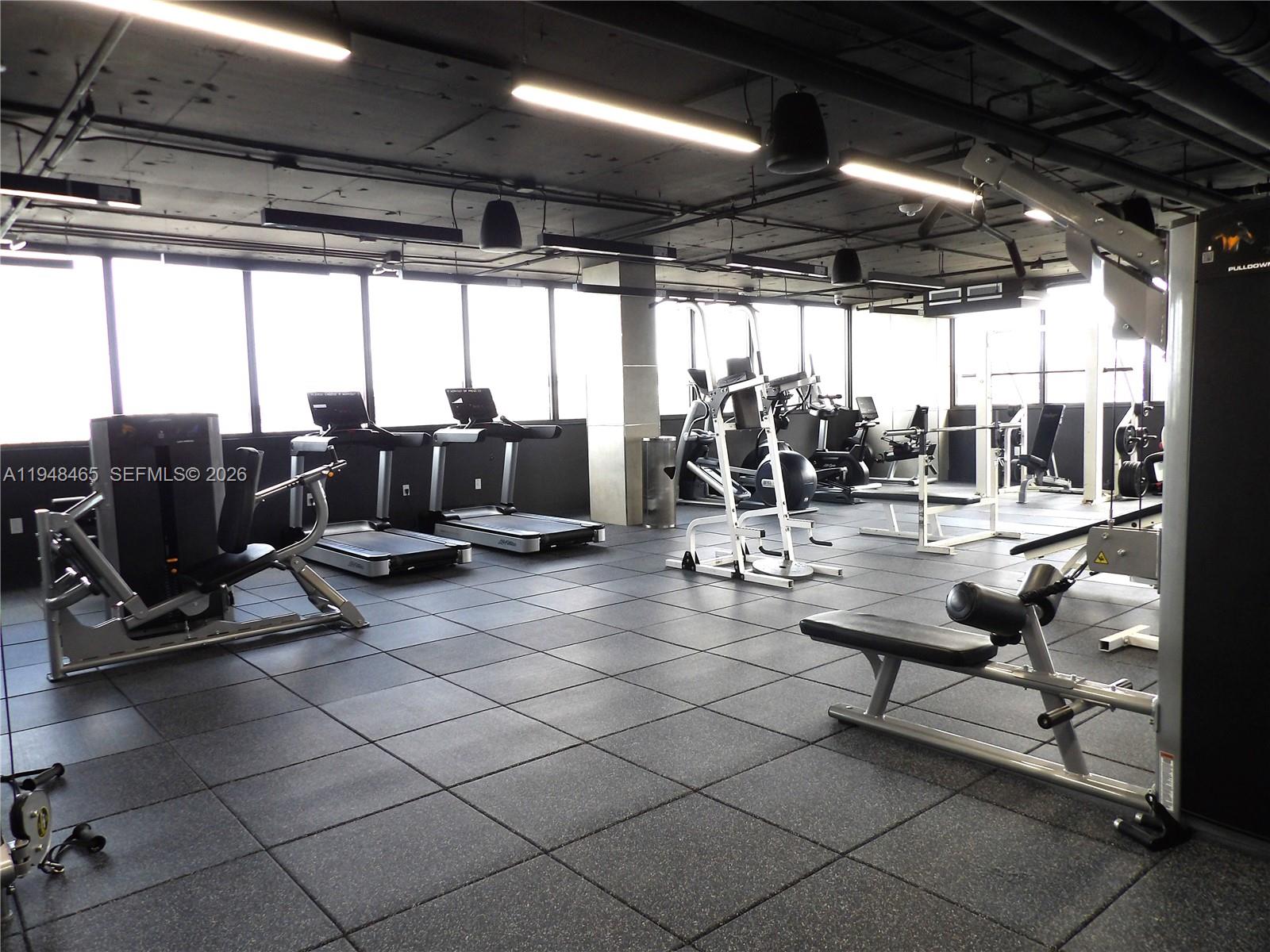 555 Northeast 15th Street, Unit 14E Miami, FL 33132 - Photo 17 of 26 a living room with patio furniture and a floor to ceiling window