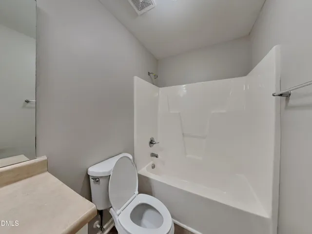 a white toilet sitting next to a bath tub