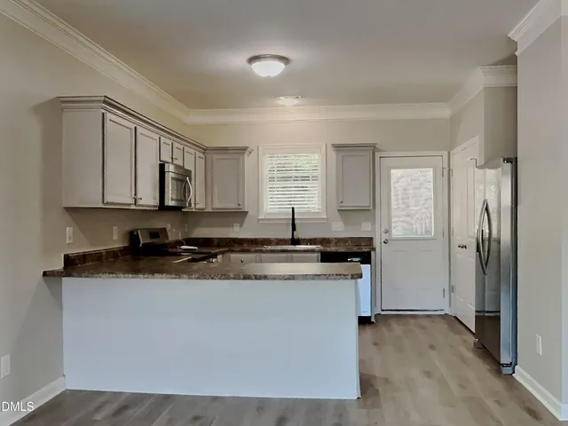 a kitchen with stainless steel appliances granite countertop a stove a sink and a refrigerator