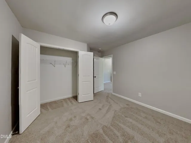 an empty room with an entryway and closet area