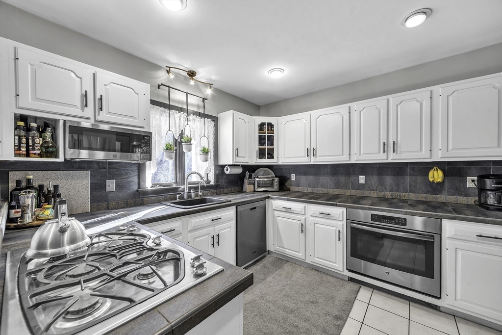32 Stebbins Road Monson, MA 01057 - Photo 11 of 33 a kitchen with stainless steel appliances granite countertop a stove top oven a sink dishwasher and cabinets with wooden floor