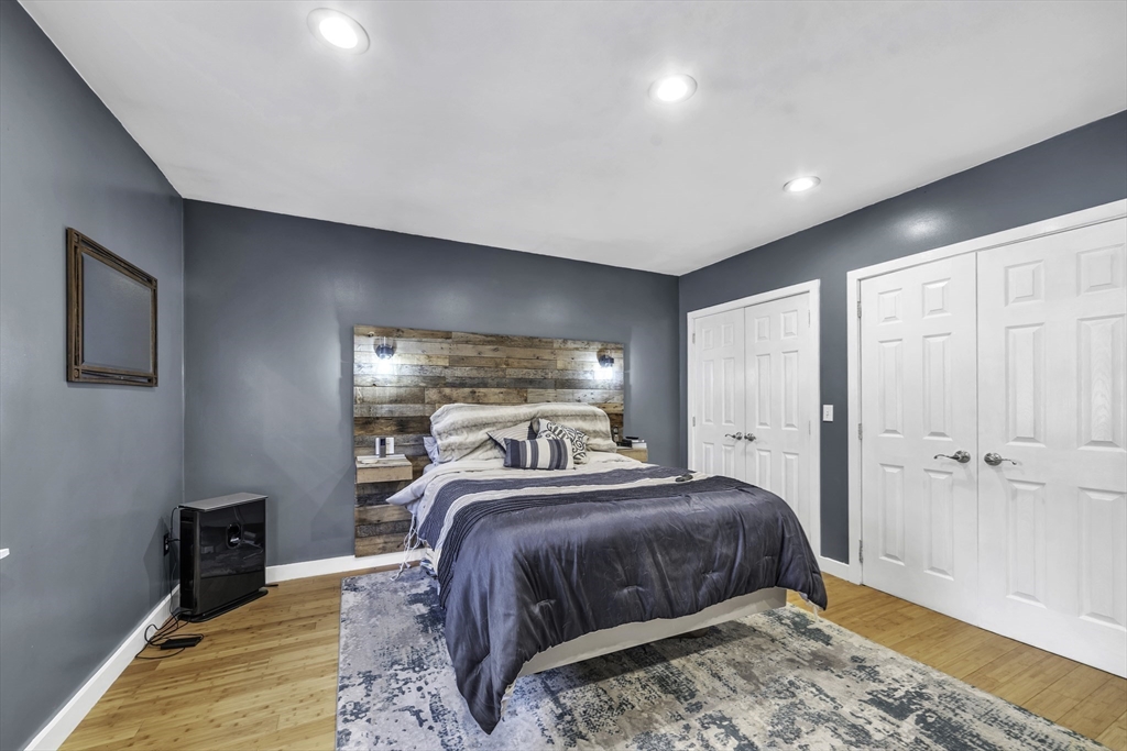 32 Stebbins Road Monson, MA 01057 - Photo 13 of 33 a bedroom with a large bed and a wooden floor
