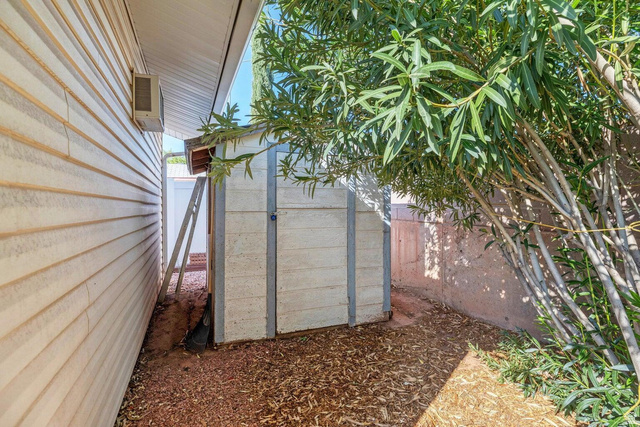 2990 East Riverside Drive, Unit 173 St. George, UT 84790 - Photo 26 of 38 White siding exterior with a pitched roofline, accompanied by an outdoor storage shed