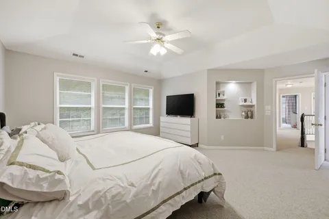 a bedroom with a large bed and a flat tv screen