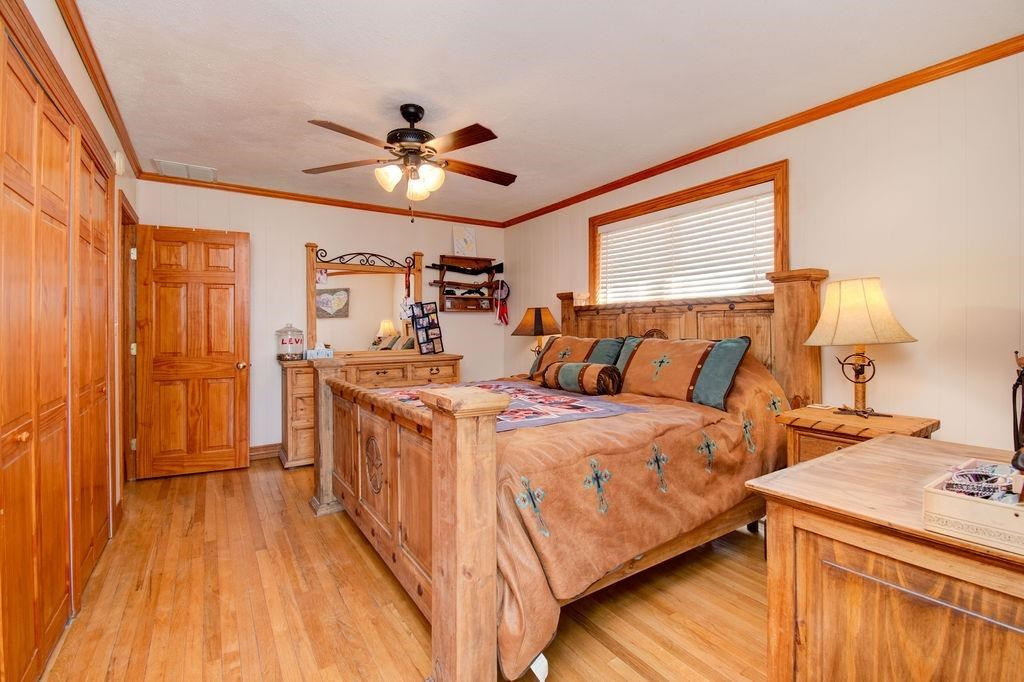 3298 Hawk Road Levelland, TX 79336 - Photo 13 of 32 a bed room with a bed and a chandelier
