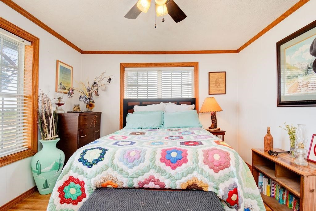 3298 Hawk Road Levelland, TX 79336 - Photo 17 of 32 a bedroom with a bed a dresser and a painting on the wall