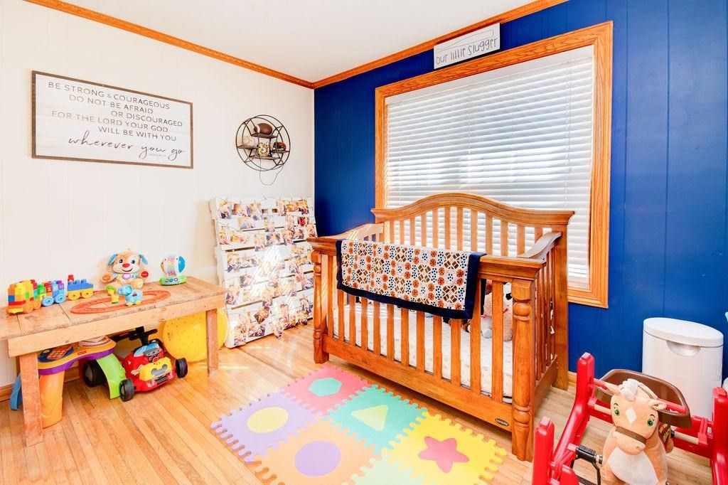 3298 Hawk Road Levelland, TX 79336 - Photo 20 of 32 a bedroom with baby bed toys and paintings on the wall