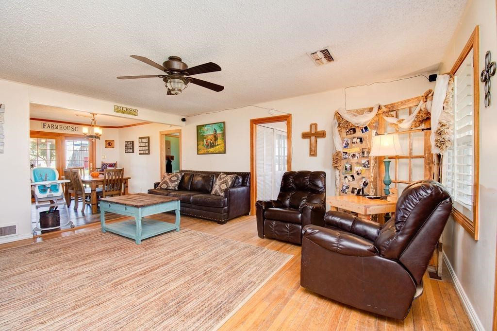 3298 Hawk Road Levelland, TX 79336 - Photo 4 of 32 a living room with furniture ceiling fan and a wooden floor