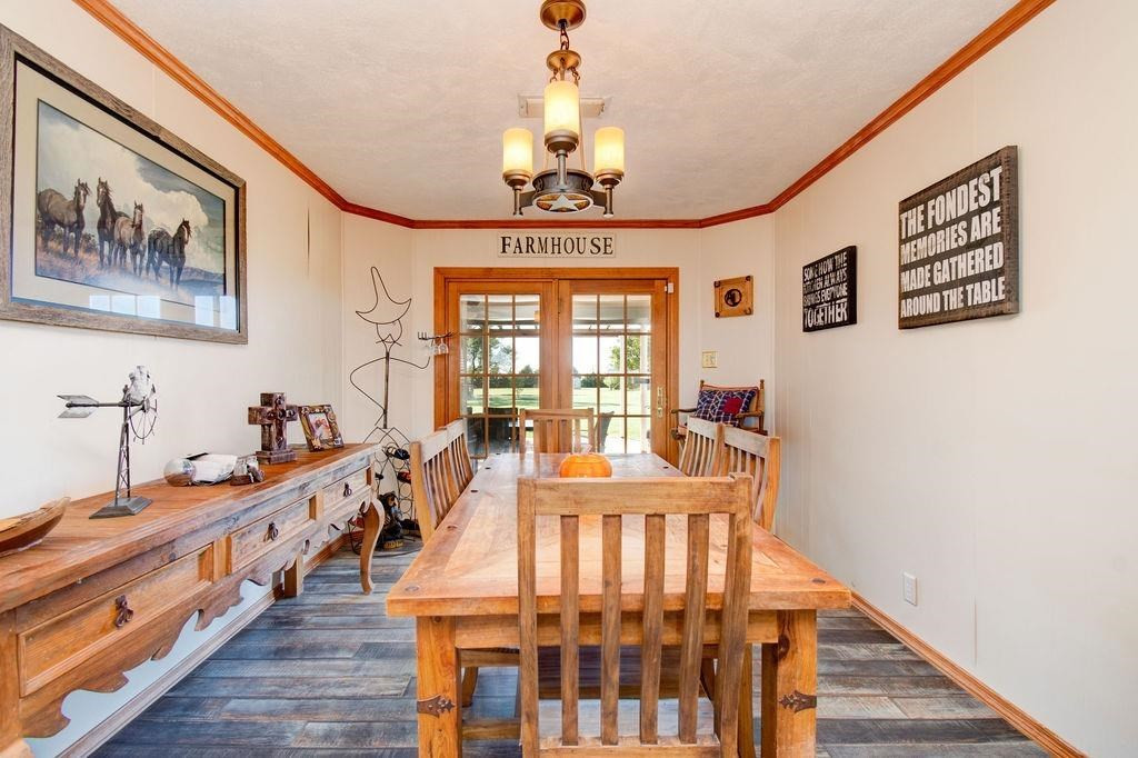 3298 Hawk Road Levelland, TX 79336 - Photo 8 of 32 a dining room with wooden floor and a chandelier