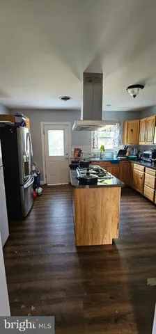 a kitchen with stainless steel appliances granite countertop a stove a refrigerator a sink a microwave dining table and chairs