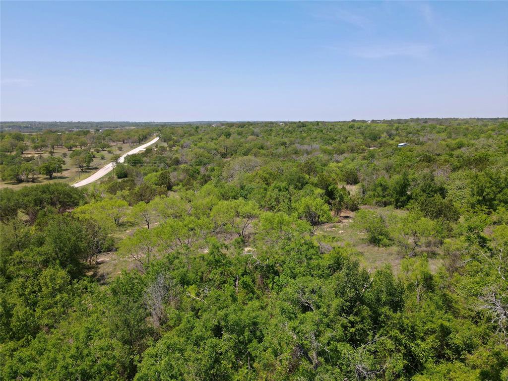 Birds eye view of property with a wooded view
