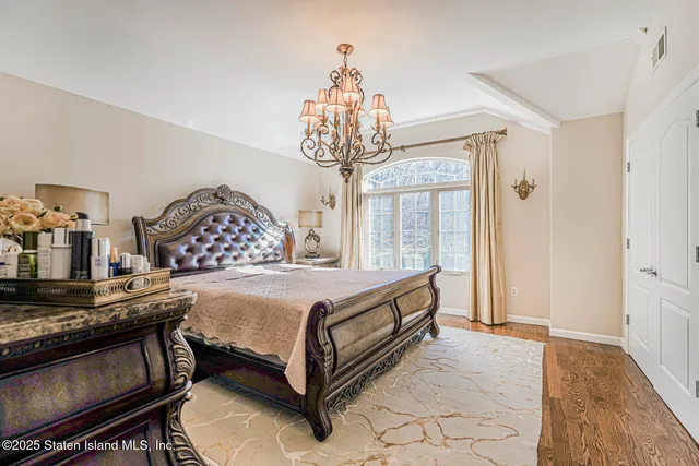 a bedroom with a bed and a chandelier