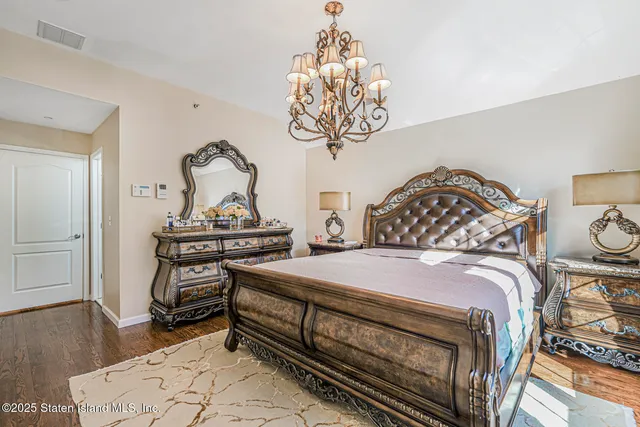 a bedroom with bed and wooden floor
