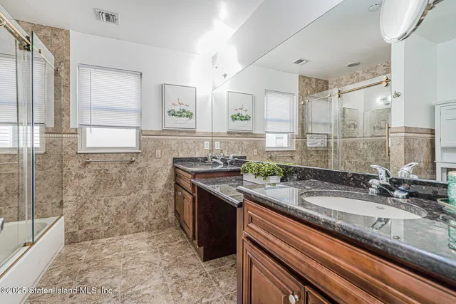 a bathroom with a granite countertop sink a mirror and a shower